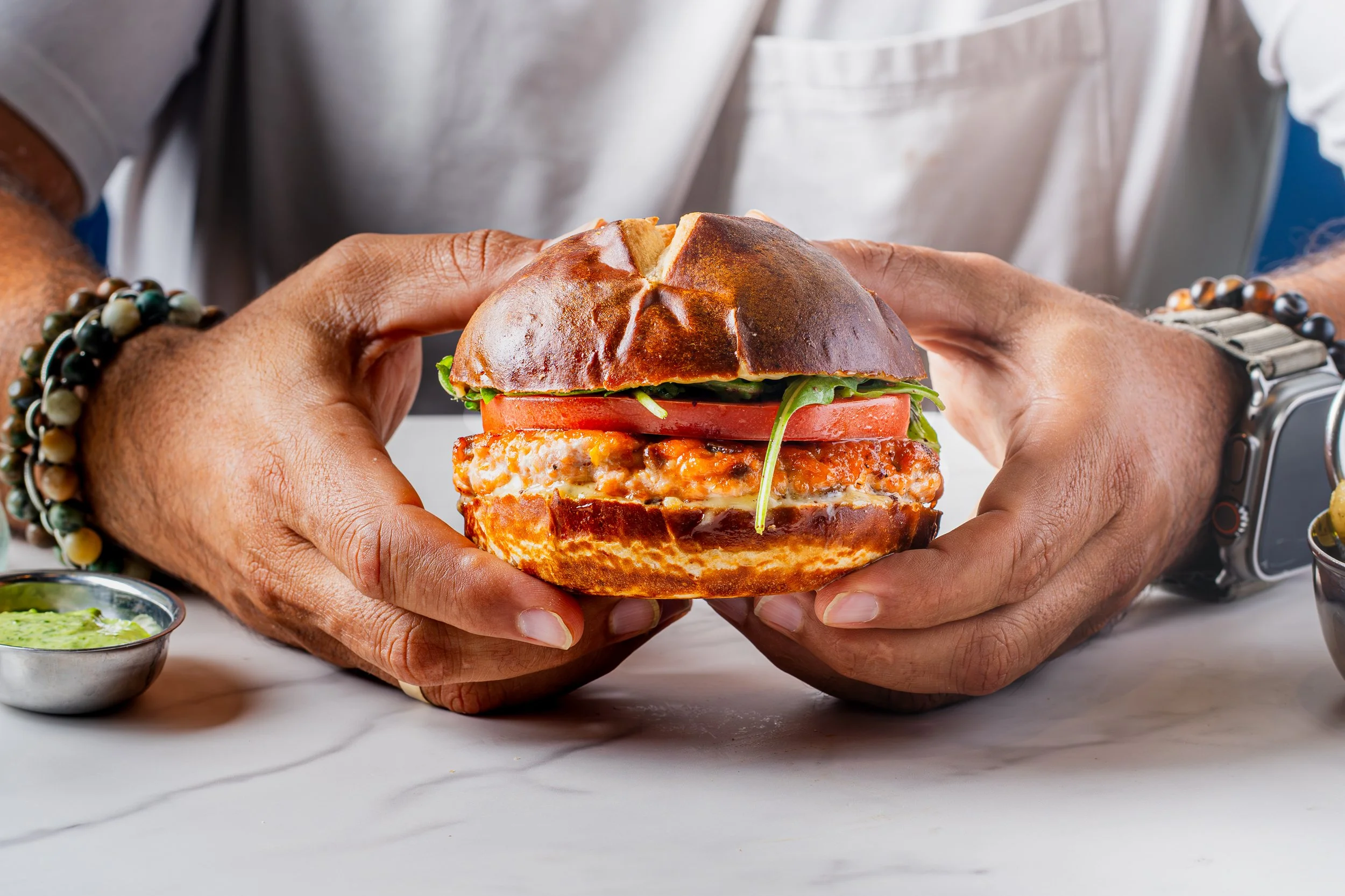 A chef holding a styled burger for food photography.