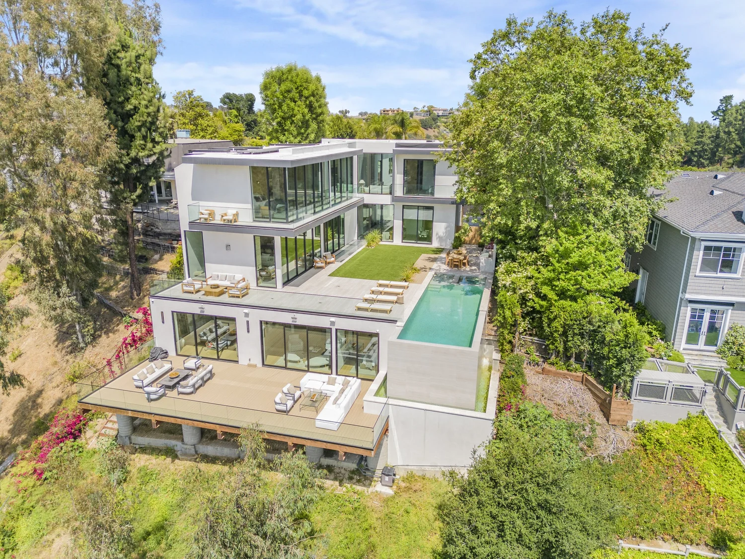 Aerial exterior view of a modern luxury property with outdoor living spaces.